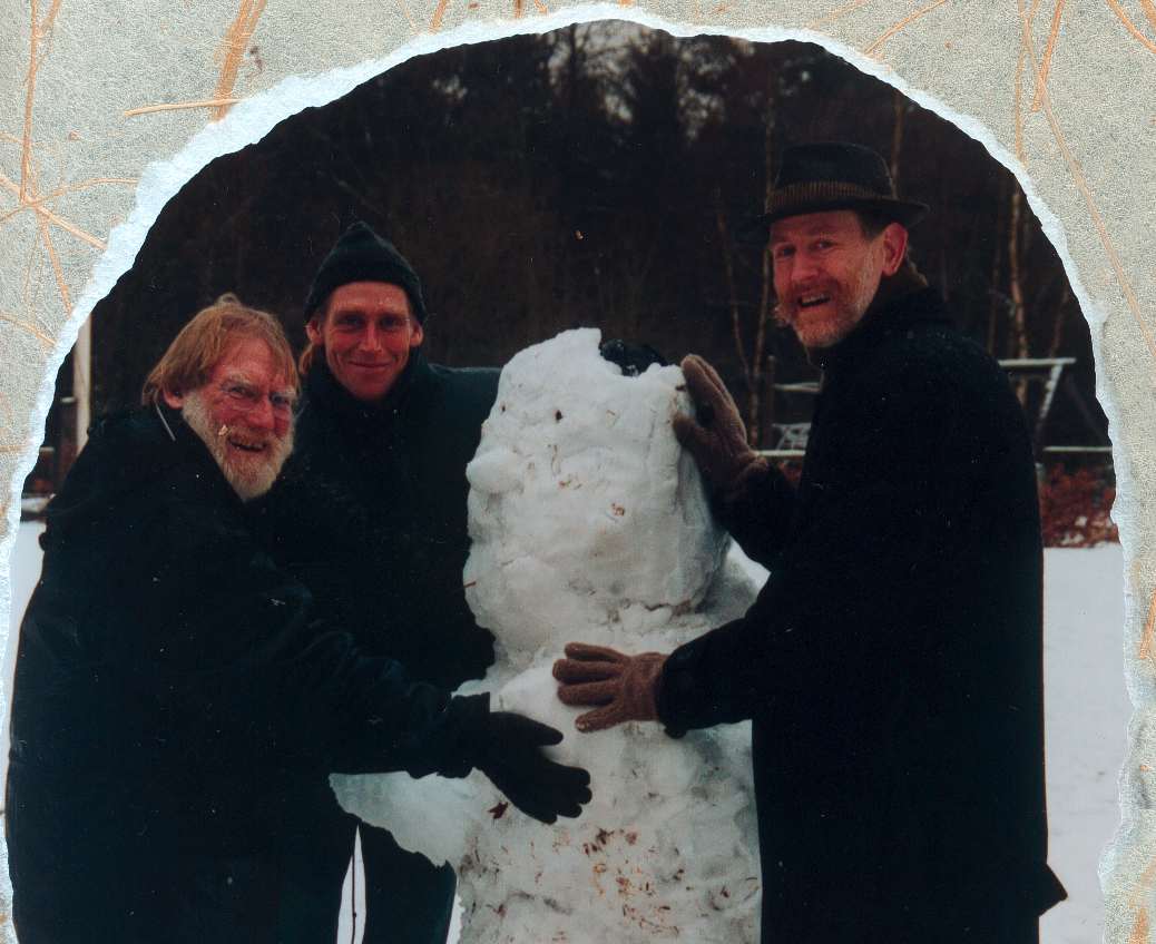Foto: far og to sønner bygger snemand